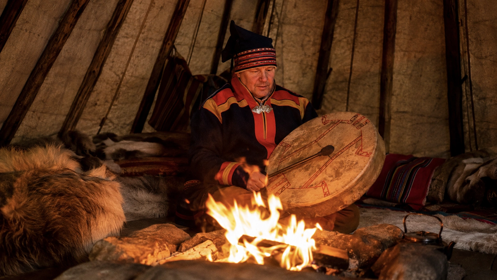 Sami guide sharing stories inside a traditional lavvu near Kiruna