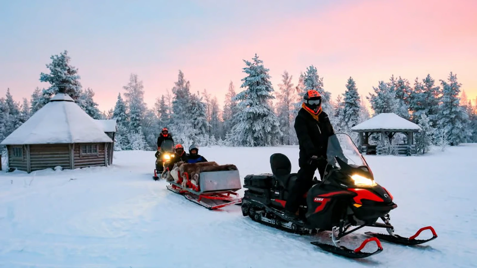 Snowmobile sleigh ride through snowy forest near Kiruna in Swedish Lapland